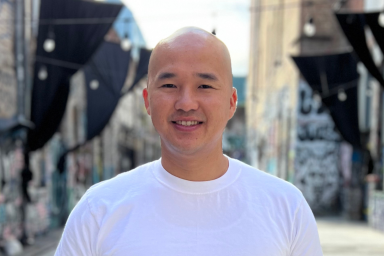 Picture of John Lam smiling in a White t-shirt